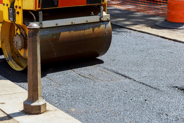 Roller und arbeiter beim asphaltieren und reparieren von stadtstraßen