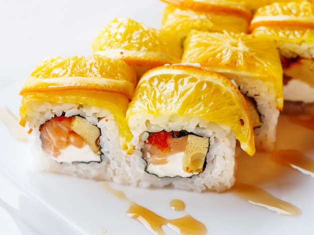 Rollitos de arroz, alga nori, salmón, queso crema, huevo de gallina, caviar masago, naranja.