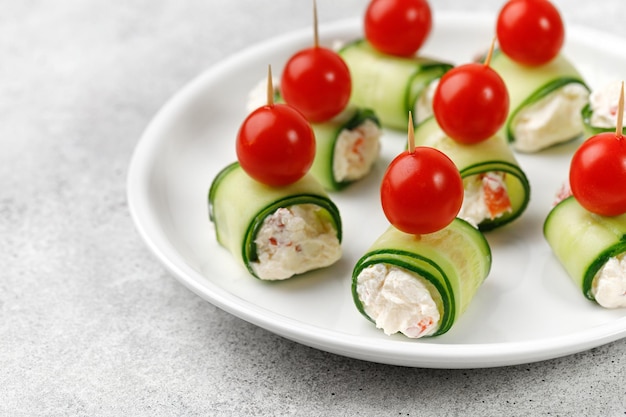 Rollitos de canapés de pepino rellenos con queso crema servidos Aperitivo navideño para una mesa festiva