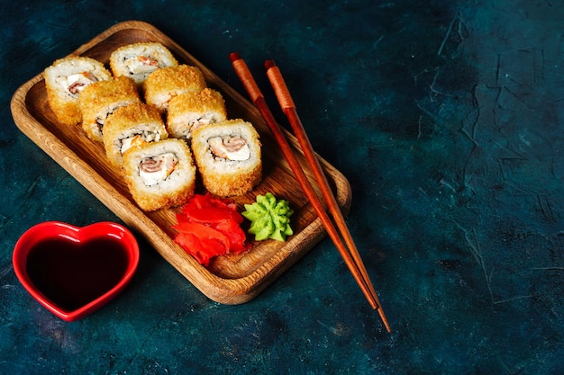 Rollitos fritos en tempura con caviar de atún, camarones de salmón y queso sobre fondo oscuro con espacio para copiar Foto de alta calidad