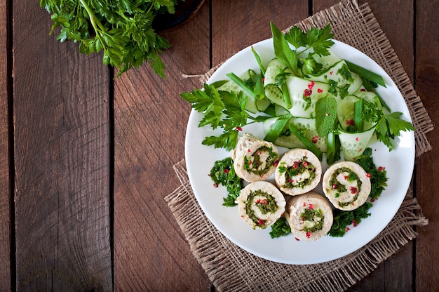 Rollitos de pollo al vapor con verduras y ensalada de verduras frescas en un plato marrón