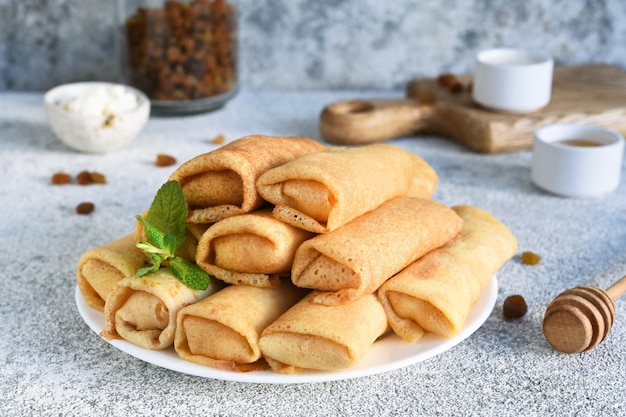 Rollitos de primavera finos sobre un fondo de hormigón ligero. Platillos. Plato nacional y tradicional de Bielorrusia y Ucrania. Panqueques