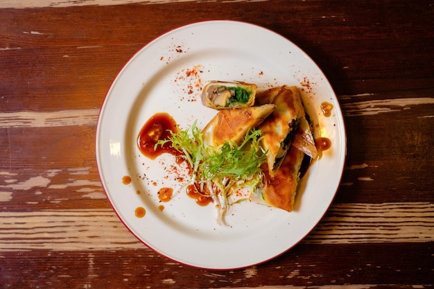 Rollitos de primavera en masa filo con champiñones y chuka Cocina oriental panasiática en mesa de madera