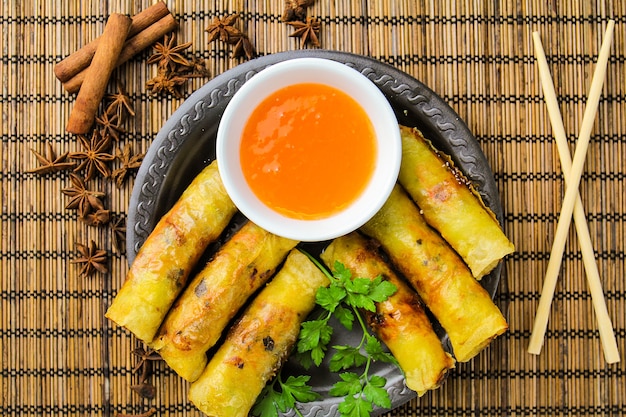 Rollitos de primavera con salsa dulce en placa negra