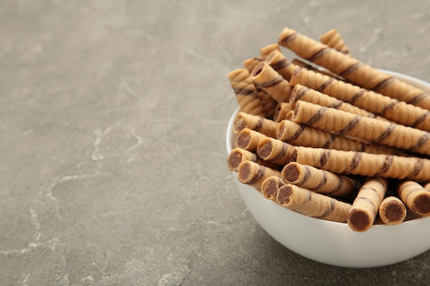 Rollo de barquillo de café con crema de café sobre fondo gris