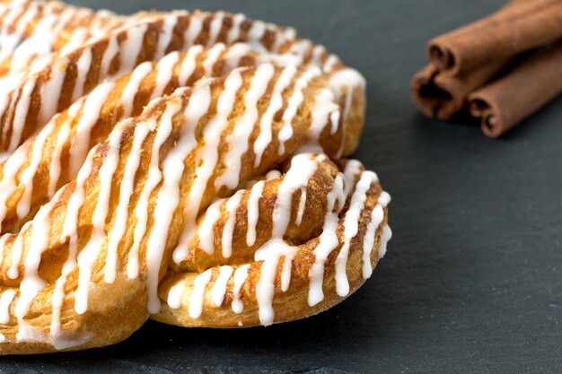 Rollo de canela o postre de bollo de canela en pizarra negra panaderías clásicas americanas o francesas bokeh