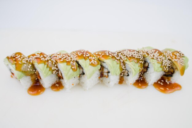 Un rollo de cocina japonesa con aguacate y semillas de sésamo