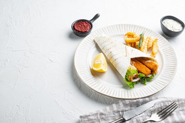 Rollo de dedos de pescado y salsa tártara en un plato