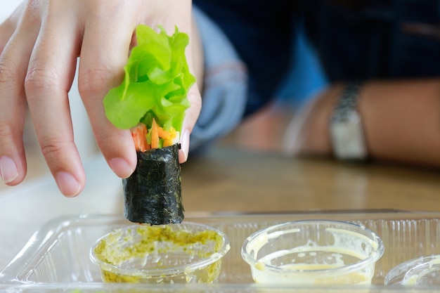 rollo de ensalada en la mano de niña