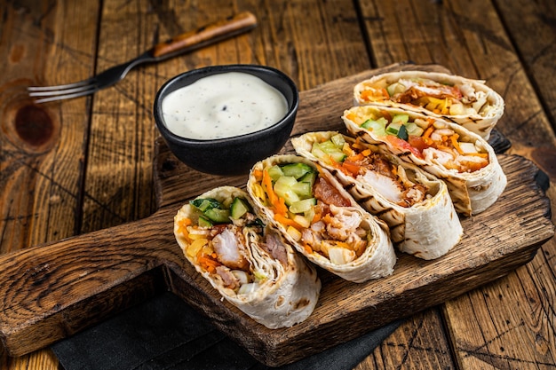 Rollo de envoltura de pollo durum doner kebab con ensalada de carne y verduras Fondo de madera Vista superior