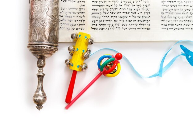 El Rollo de Ester y los objetos de la Fiesta de Purim sobre un fondo blanco