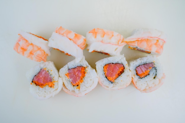 Un rollo japonés con camarones y salmón con arroz blanco
