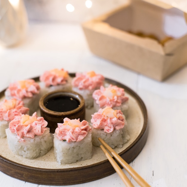 Rollo de lava con queso crema sobre placa de madera blanca con guirnaldas de luces