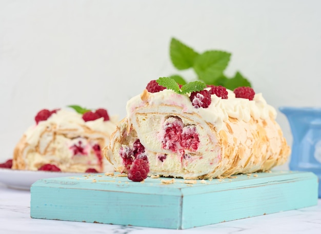 Rollo de merengue al horno con nata y frambuesa roja fresca fondo blancox9