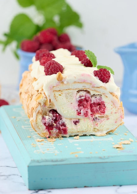 Rollo de merengue al horno con nata y frambuesa roja fresca fondo blancox9