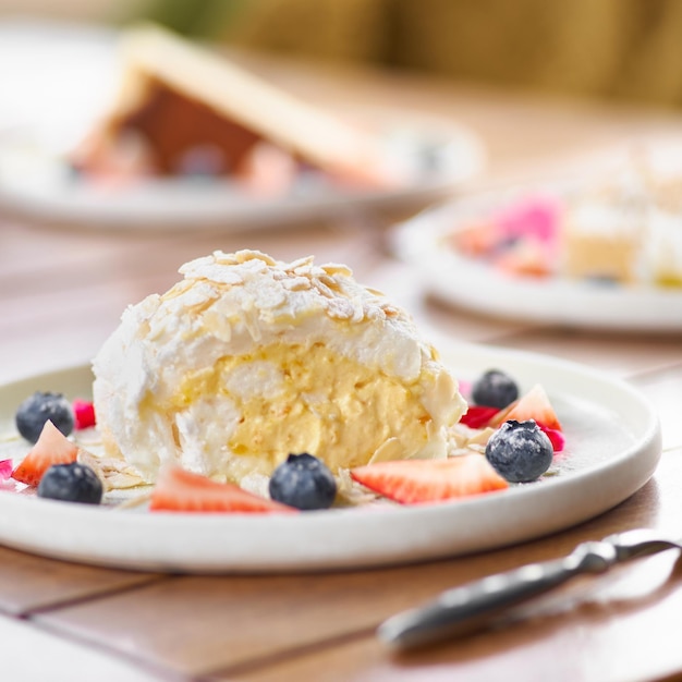 Rollo de merengue con fresas arándanos frambuesas y arándanos Postre decorado con bayas frescas