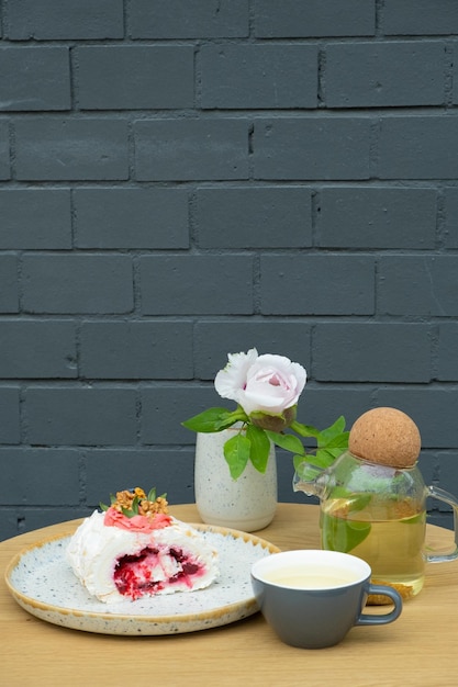 Rollo de merengue con té en una mesa en un café Bodegón de alimentos dulces