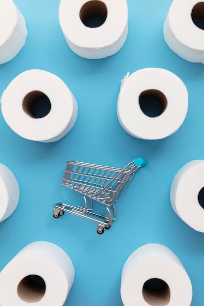 Rollo de papel higiénico blanco con un carrito de compras sobre un fondo azul.