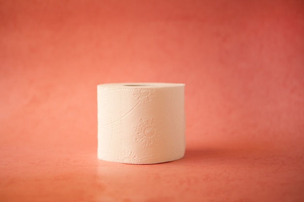 Rollo de papel higiénico blanco suave sobre fondo rosa pastel brillante Concepto de higiene y crysis