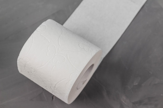 Un rollo de papel higiénico sobre un fondo gris