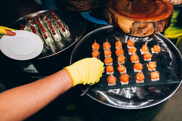 Rollo de pescado rojo en un pincho. filete de salmón con eneldo y limón. plato con pequeños bocadillos