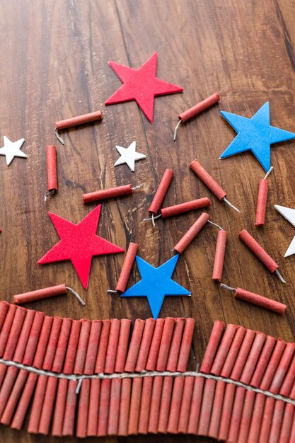 Foto rollo de petardos con estrellas rojas, blancas y azules sobre mesa de madera.