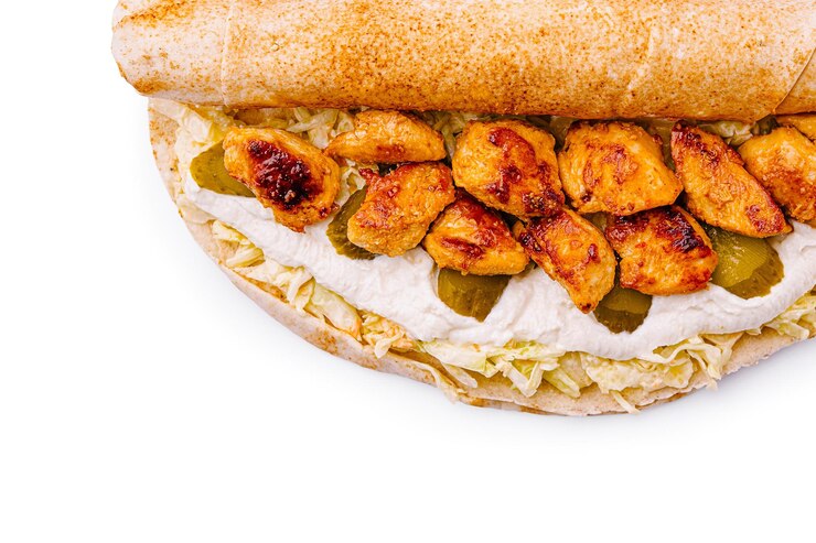 Rollo de pollo con salsa cremosa y pepinillos servido en un pan plano