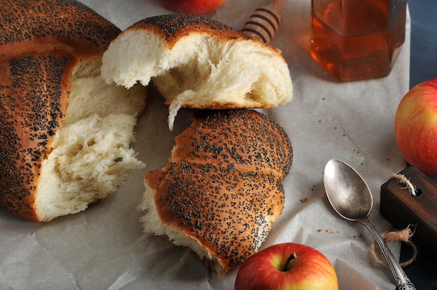 Rollo con semillas de amapola, desgarrado en pedazos primer tiro con manzanas y miel