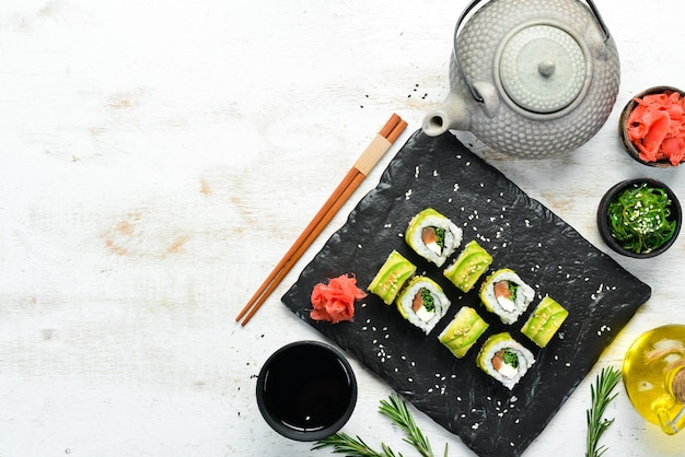 Rollo de sushi con aguacate, salmón y cebolla Espacio libre para el texto Cocina tradicional japonesa Vista superior Estilo rústico
