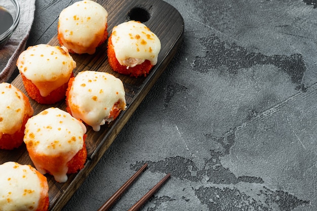 Rollo de sushi al horno con camarones y tapa de caviar masago. Plato de restaurante de sushi tradicional, en piedra gris