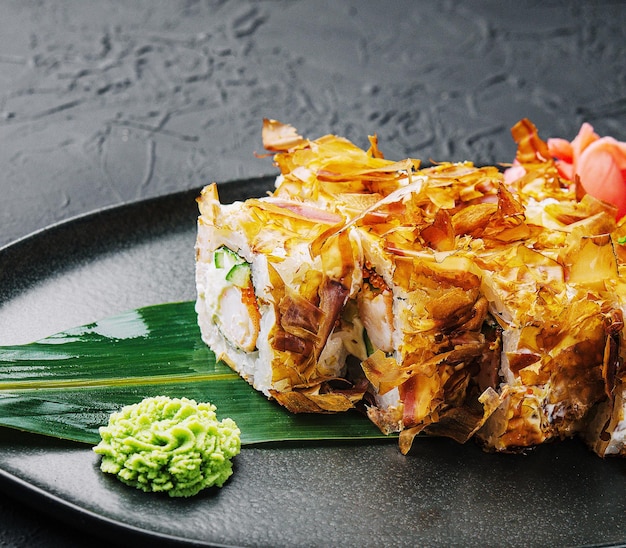 Rollo de sushi bonito en un plato oscuro