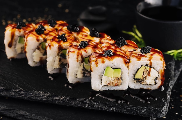 Un rollo de sushi de California con verduras de atún y salsa unagi