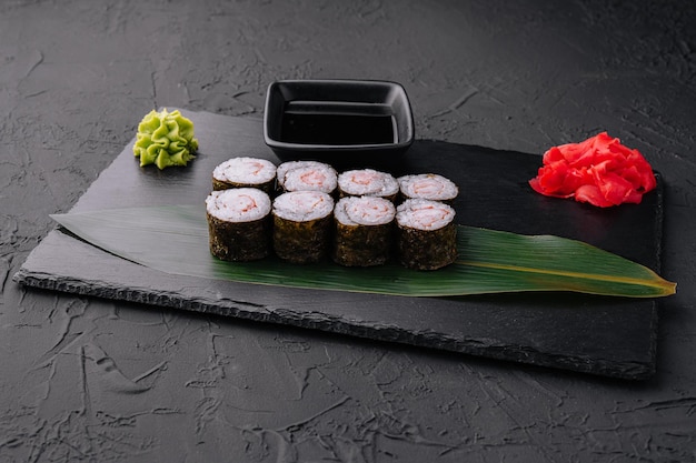 Rollo de sushi ebi maki con camarones en tablero negro