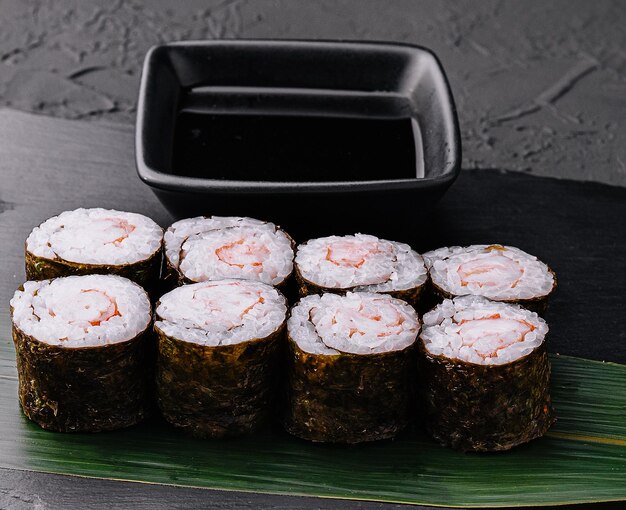 Rollo de sushi ebi maki con camarones en tablero negro