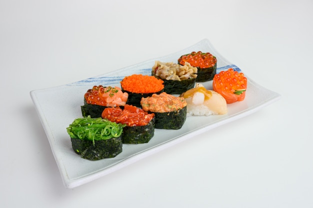 Rollo de sushi japonés de algas con Ikura, Ebiko, Hotate, Wakame, Kurage en plato de cerámica