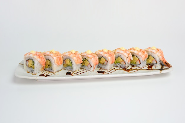 Rollo de sushi japonés de camarones o Ebi con salsa de kani, tamago y teriyaki