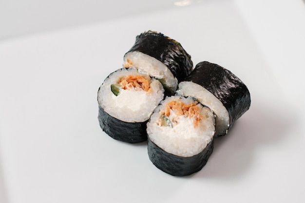 Rollo de sushi maki con salmón en plato blanco