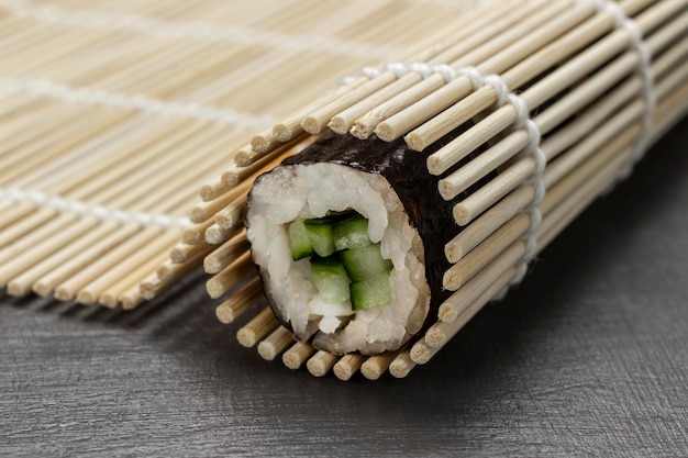 Rollo de sushi nori en una estera de bambú