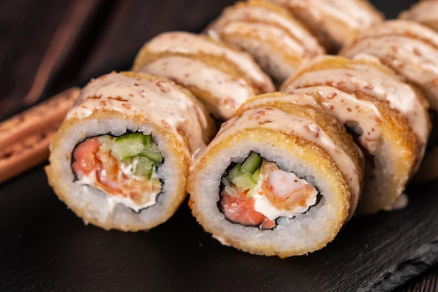 Rollo con sushi de pescado con palillos cerca del concepto de comida asiática