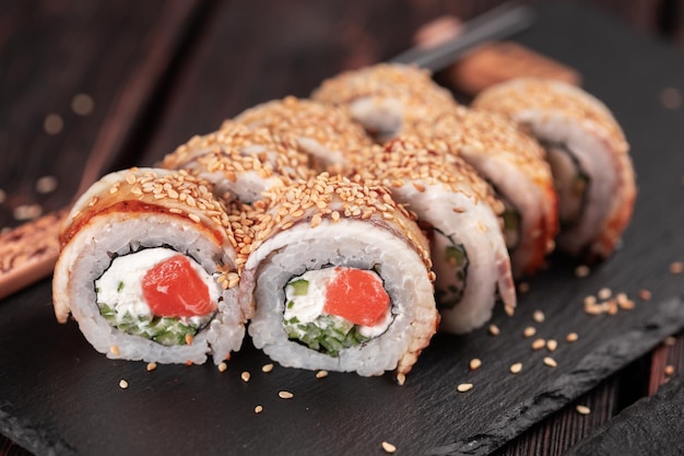 Rollo con sushi de pescado con palillos concepto de comida asiática