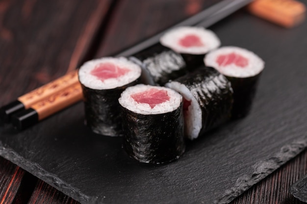 Rollo con sushi de pescado con palillos concepto de comida asiática