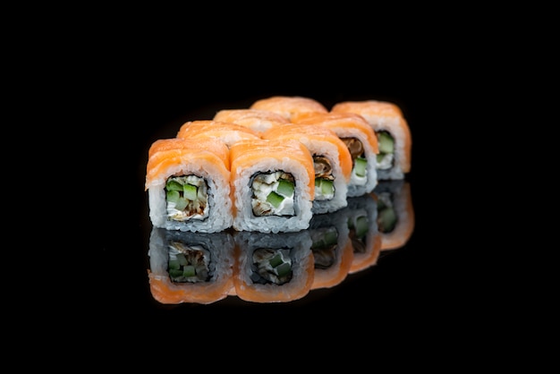 Rollo De Sushi En Un Reflejo De Pared Negro. Comida japonesa. De cerca.