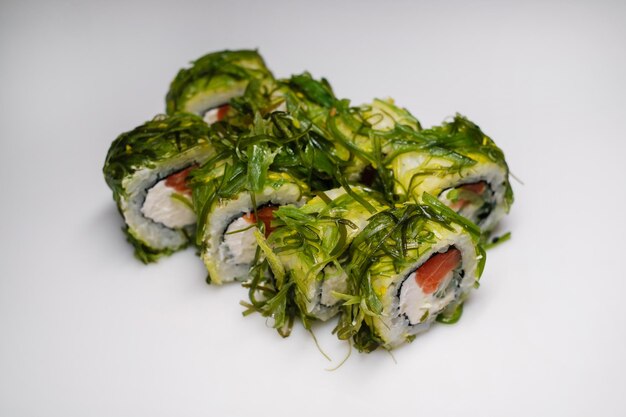 Rollo de sushi con salmón y chuka Vista lateral de la cocina tradicional japonesa