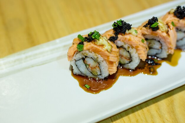 Rollo de sushi de salmón a la parrilla en un plato blanco