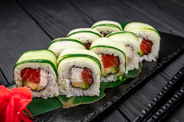 Rollo de sushi con salmón y queso crema envuelto en pepino