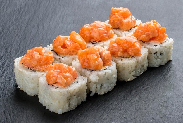 Rollo de sushi con salmón y queso sobre fondo negro