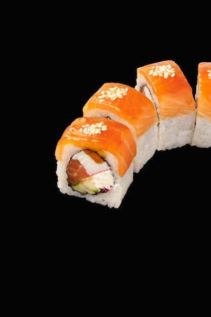 Rollo de sushi Salmón Salmón ahumado en frío Queso Filadelfia Cangrejo de nieve Tobiko Caviar Pepino Salsa unagi Semillas de sésamo Aisladas sobre fondo negro