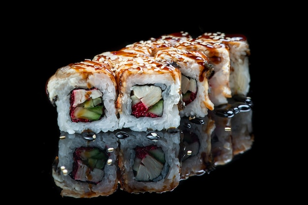 Rollo de sushi sobre un fondo negro reflexión comida japonesa cerrar