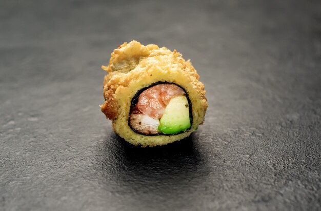 un rollo de sushi sobre un fondo de piedra