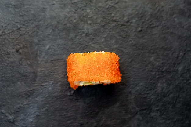 un rollo de sushi sobre un fondo de piedra